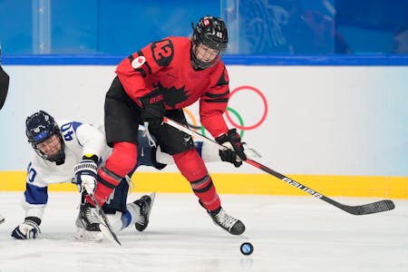 Canada's Claire Thompson (42) tries to play the puck against Finland during the 2002 Olympics in Beijing.