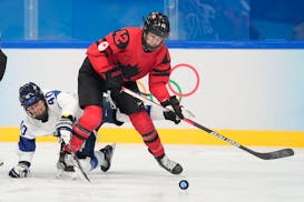 Canada's Claire Thompson (42) tries to play the puck against Finland during the 2022 Olympics in Beijing.
