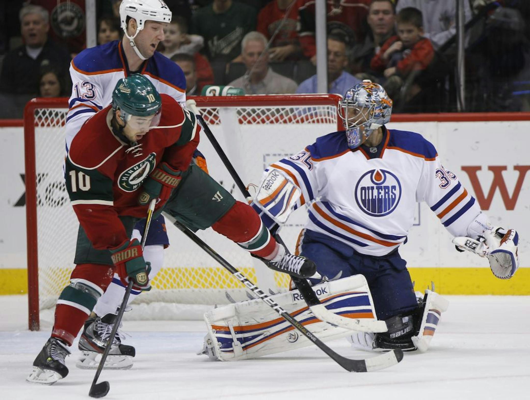 At the Wild game against the Oilers at the Xcel Center in St. Paul,Devin Setoguchi(10) battled with Cam Barker(13) trying to score against goalie Nikolai Khabibulin(35) in the third period .