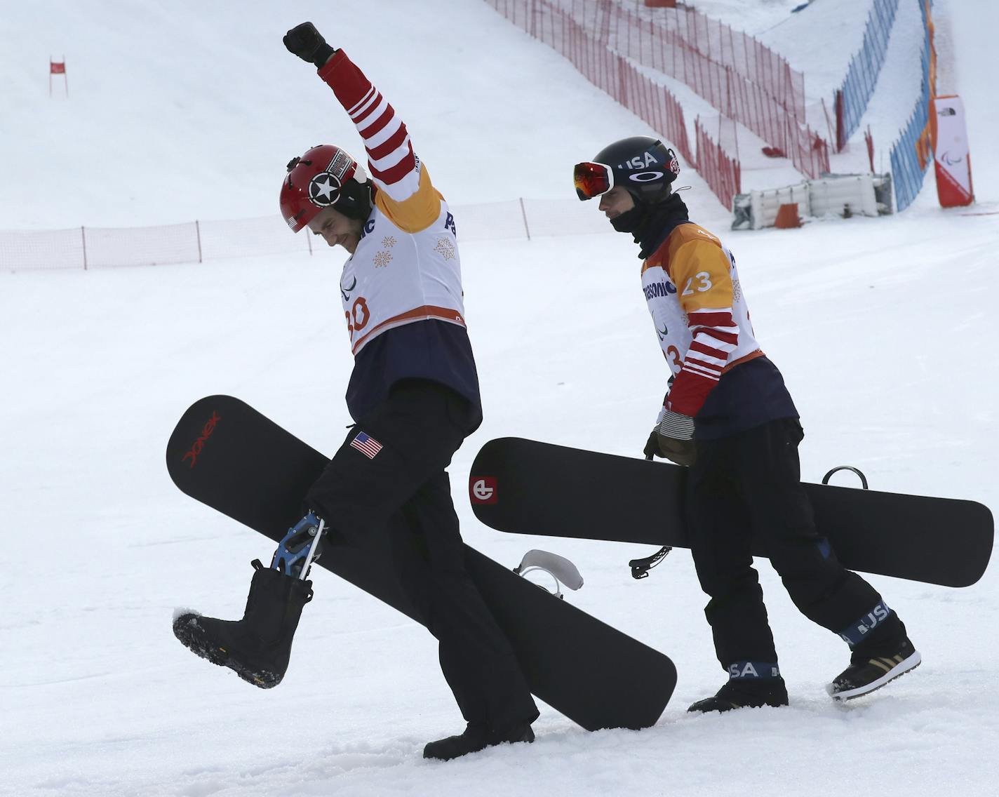 Winners of the Men's Snowboard Cross SB-LL1 event from left gold medalist Mike Schultz of United States and bronze medalist Noah Elliott of United States leave after a ceremony at the 2018 Winter Paralympics in Pyeongchang, South Korea, Monday, March 12, 2018. (AP Photo/Ng Han Guan)