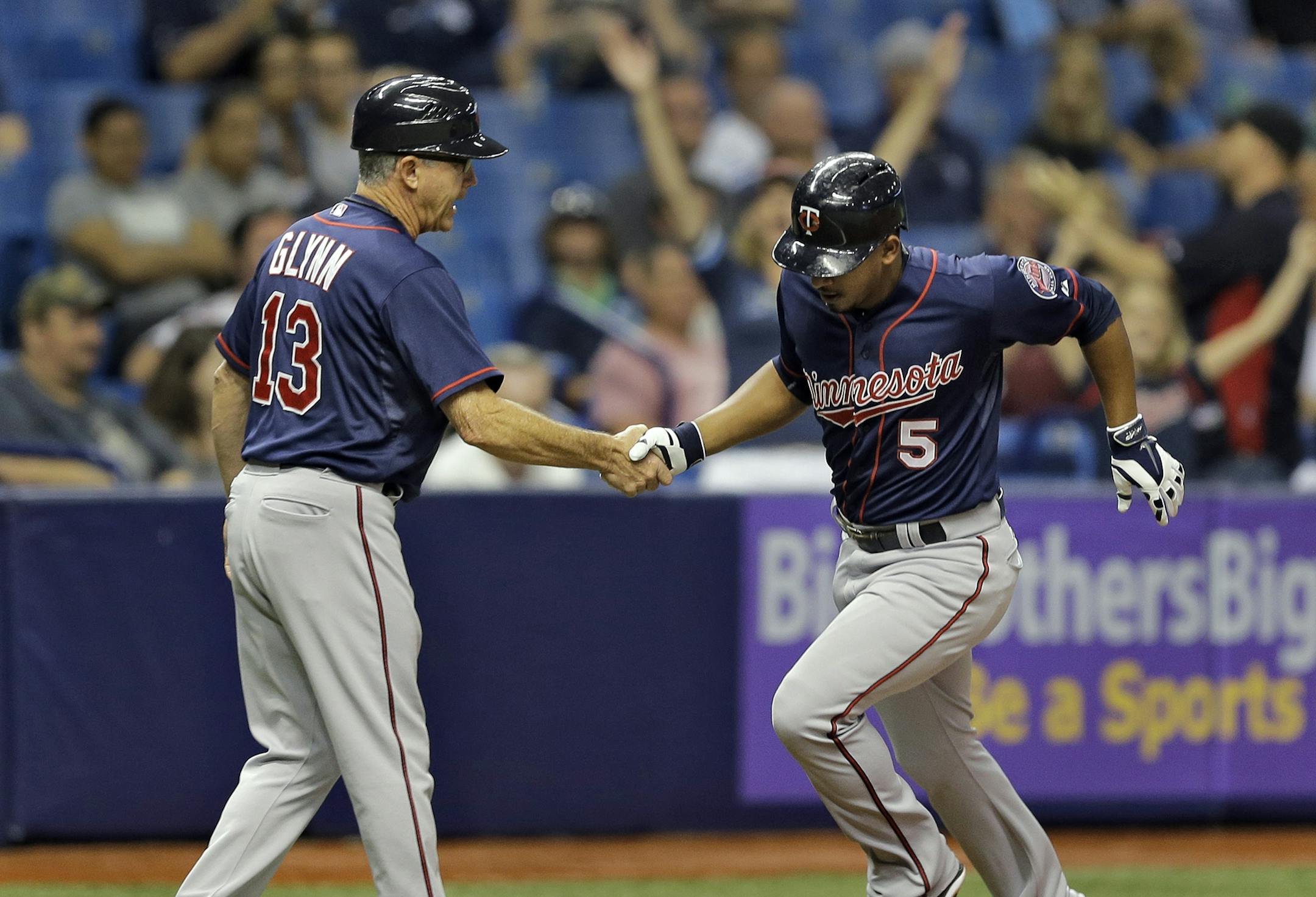 Minnesota Twins' Eduardo Escobar (5) shakes hands with third base coach Gene Glynn after his home run off Tampa Bay Rays starting pitcher Chris Archer during the sixth inning of a baseball game Wednesday, Aug. 26, 2015, in St. Petersburg, Fla. (AP Photo/Chris O'Meara)
