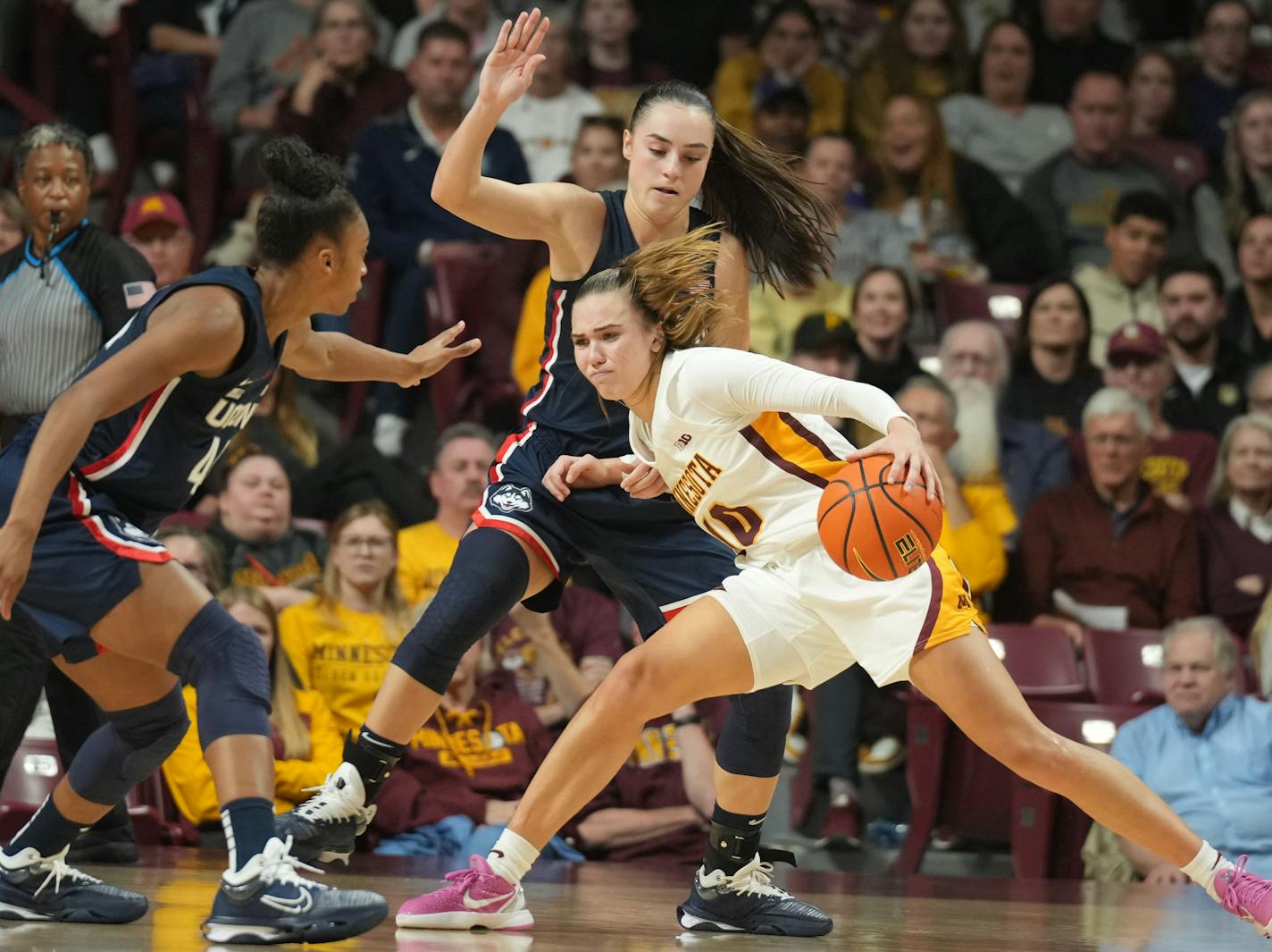 Minnesota Golden Gophers guard Mara Braun (10) drives against UConn Huskies guard Aubrey Griffin (44) and UConn Huskies guard Nika Muhl (10) in the second half in Minneapolis, Minn., on Sunday, Nov. 19, 2023. U of M women's basketball takes on U Conn on the return of Minnesota basketball icon Paige Bueckers. ] RICHARD TSONG-TAATARII • richard.tsong-taatarii @startribune.com