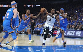 Timberwolves guard Anthony Edwards drives to the basket Thursday while defended by Shai Gilgeous-Alexander (2) and Cason Wallace (22) of the Thunder.