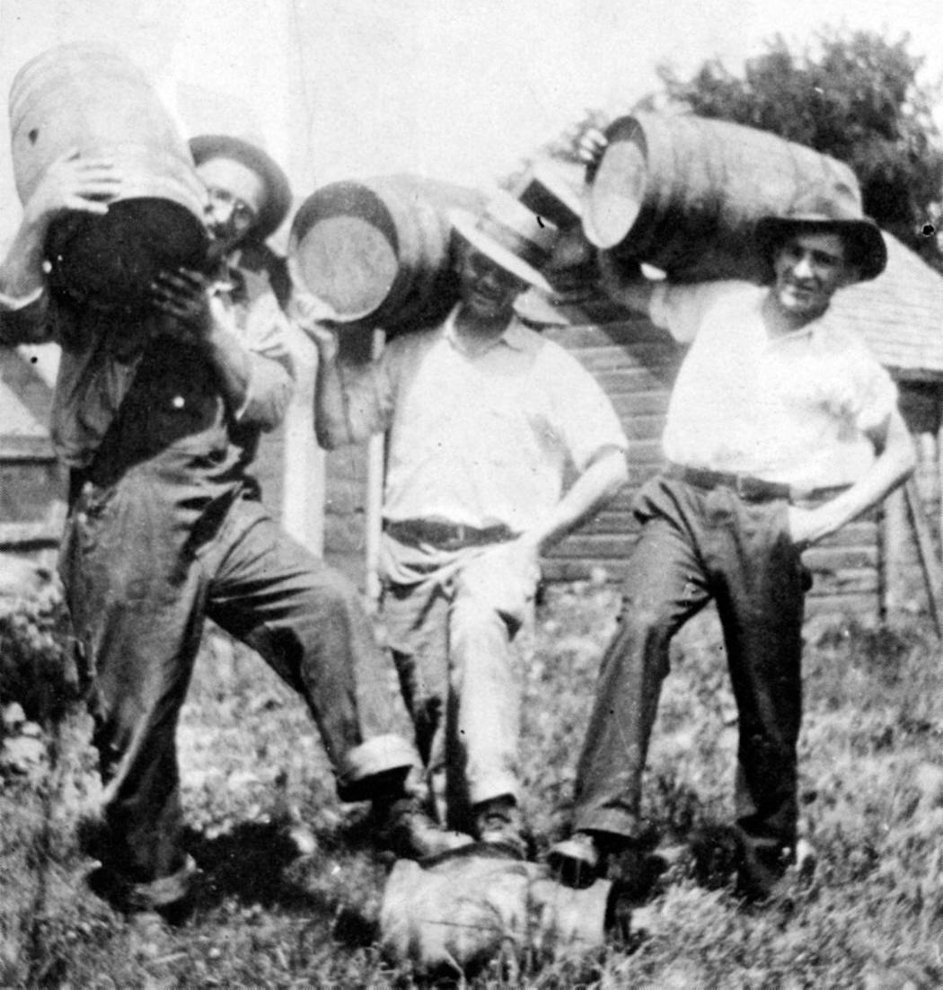 Men in Eden Valley held up barrels of Minnesota 13 moonshine.