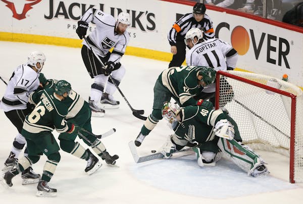 Wild goalie Devan Dubnyk made sure a loose puck stayed out of the crease while right wing David Jones (12) battled Los Angeles Kings center Anze Kopit