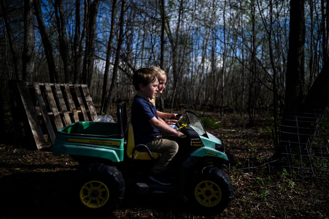 Sarah and Johnny Carlson’s children, Harlow, 6, and Sutton, 4, rode around in their John Deere Gator at home in New York Mills, Minn.