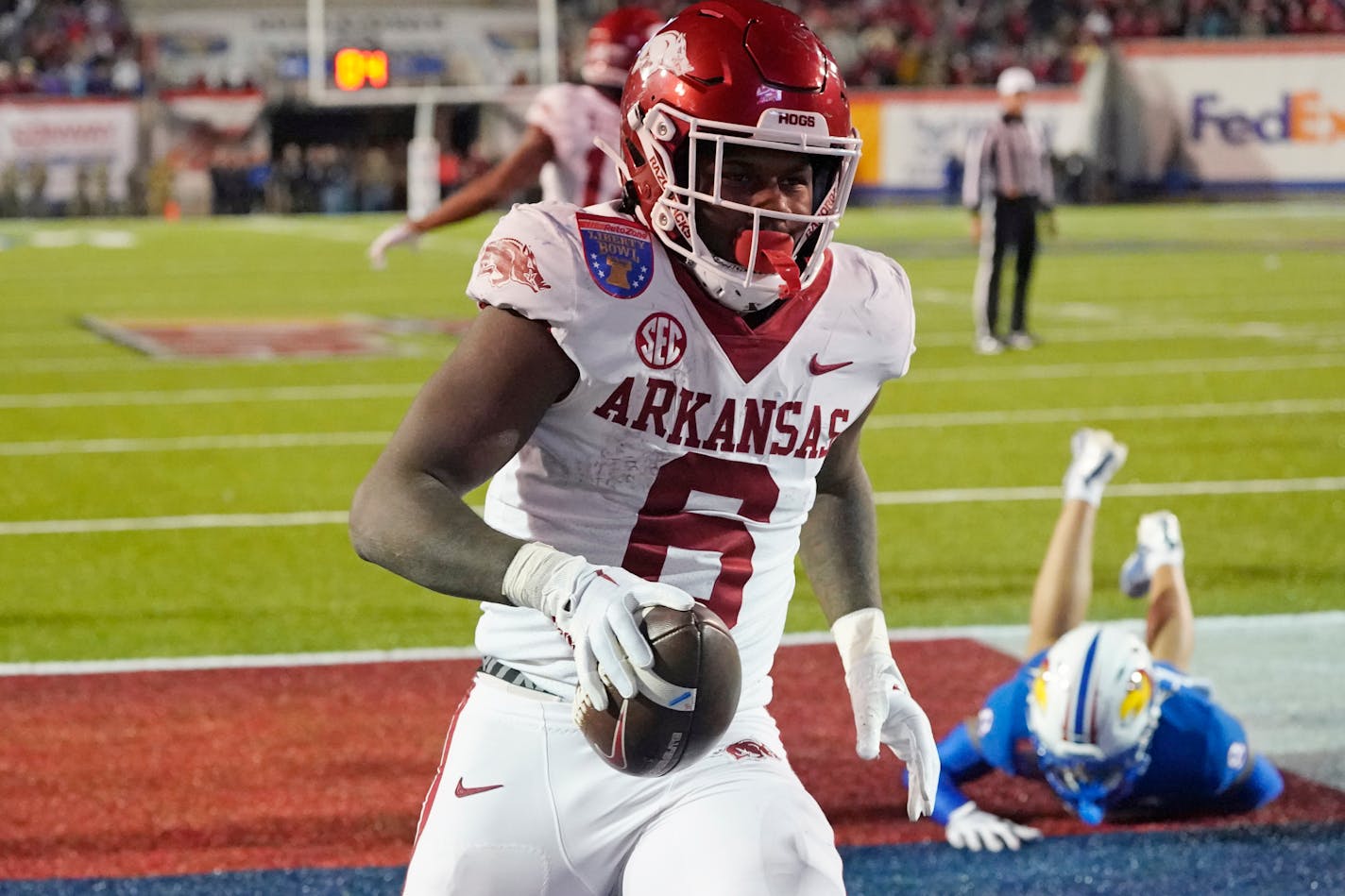 Arkansas running back Rashod Dubinion (6) leaves a Kansas defender on the turf as he scores on a 2-point conversion during the third overtime of the Liberty Bowl NCAA college football game Wednesday, Dec. 28, 2022, in Memphis, Tenn. Arkansas won 55-53. (AP Photo/Rogelio V. Solis)