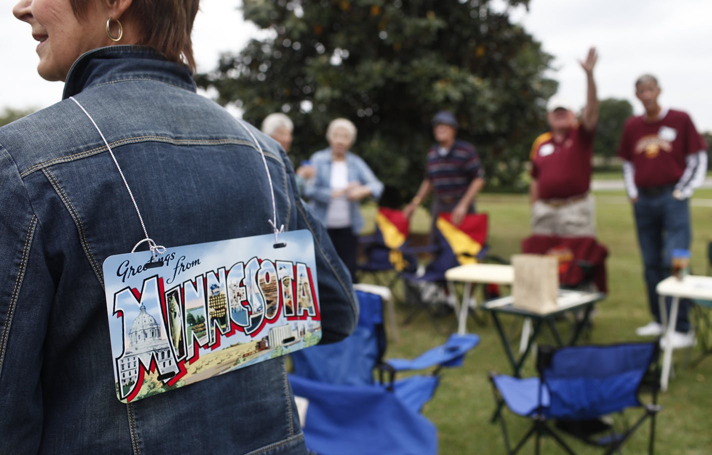 Pam Nelson, originally of Vadnais Heights, Minnesota, wears a Minnesota decorative license plate on her back as she talk to other attendees of the Minnesota Club's picnic on April 21, 2014 in The Villages, Florida. (Eve Edelheit/Special To The Star Tribune)