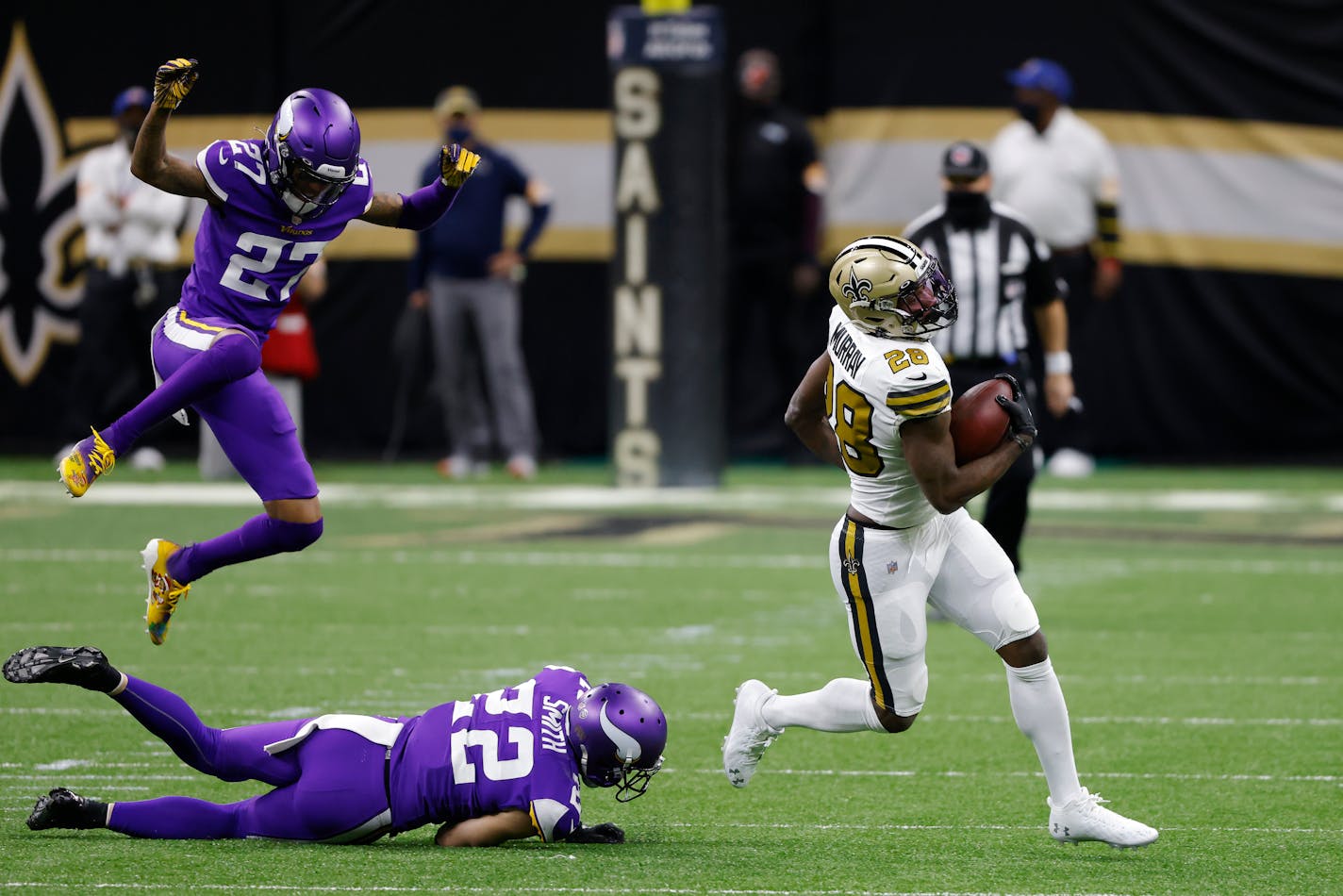 New Orleans Saints running back Latavius Murray (28) runs past Minnesota Vikings strong safety Harrison Smith (22) and cornerback Cameron Dantzler (27) during an NFL football game, Friday, Dec. 25, 2020, in New Orleans. (AP Photo/Tyler Kaufman)