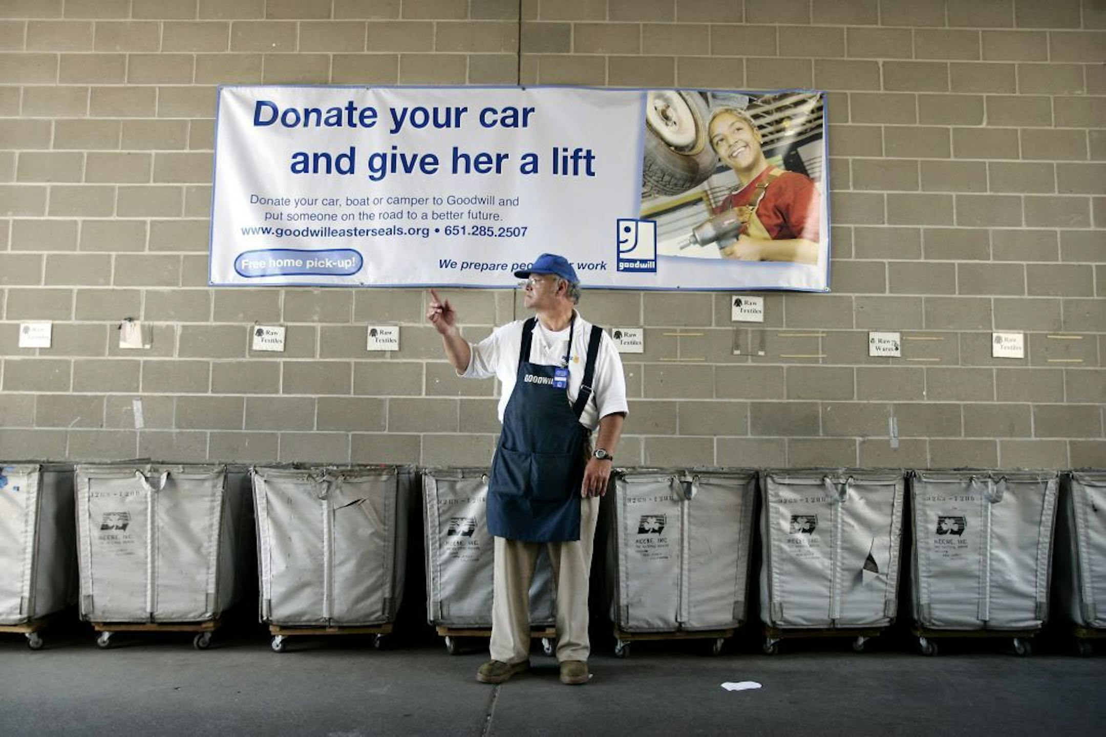 Dan Karnick of Rosemount, a donation receiver at the Goodwill in Apple Valley for 3 years, directs a vehicle into the donation drop-off center at the Apple Valley Goodwill, Apple Valley, Minn., July 6, 2005. (Ramin Rahimian/Star Tribune) GENERAL INFORMATION: The Apple Valley Goodwill is undergoing a renovation to make the store a more upscale shopping experience. It also hopes to maximize revenue for the Goodwill/Easter Seals organizations.