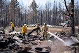 Firefighters Joshua Donahue, Chris Schlosser, Jon Settergren, Michael Hemmerich, left to right, move debris and water down hot spots in the smoldered remains of a structure as part of the efforts to combat the Camp House wildfire in Brimson, Minn. on Thursday, May 15, 2025.   ]

ALEX KORMANN • alex.kormann@startribune.com