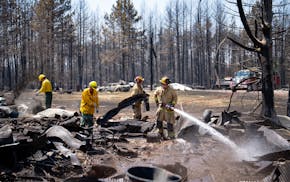 Firefighters Joshua Donahue, Chris Schlosser, Jon Settergren, Michael Hemmerich, left to right, move debris and water down hot spots in the smoldered