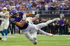 Minnesota Vikings tight end T.J. Hockenson, front, makes an attempt to catch a pass in the end zone as Los Angeles Chargers linebacker Nick Niemann de