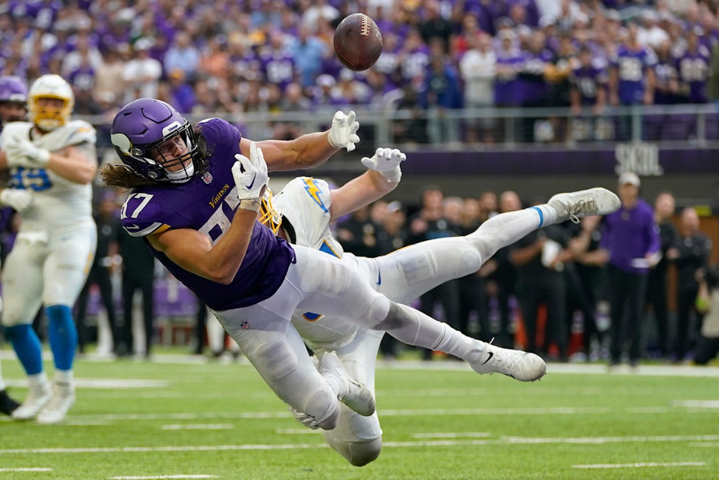 Minnesota Vikings tight end T.J. Hockenson, front, makes an attempt to catch a pass in the end zone as Los Angeles Chargers linebacker Nick Niemann defends during the second half of an NFL football game, Sunday, Sept. 24, 2023, in Minneapolis. The pass was intercepted in the end zone by Los Angeles Chargers linebacker Kenneth Murray Jr. The Chargers won 28-24. (AP Photo/Abbie Parr)