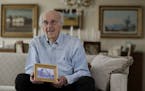 In this Friday, June 16, 2017 photo, Peter Hirschmann holds a photograph of his childhood home while posing for The Associated Press in his home in Ma