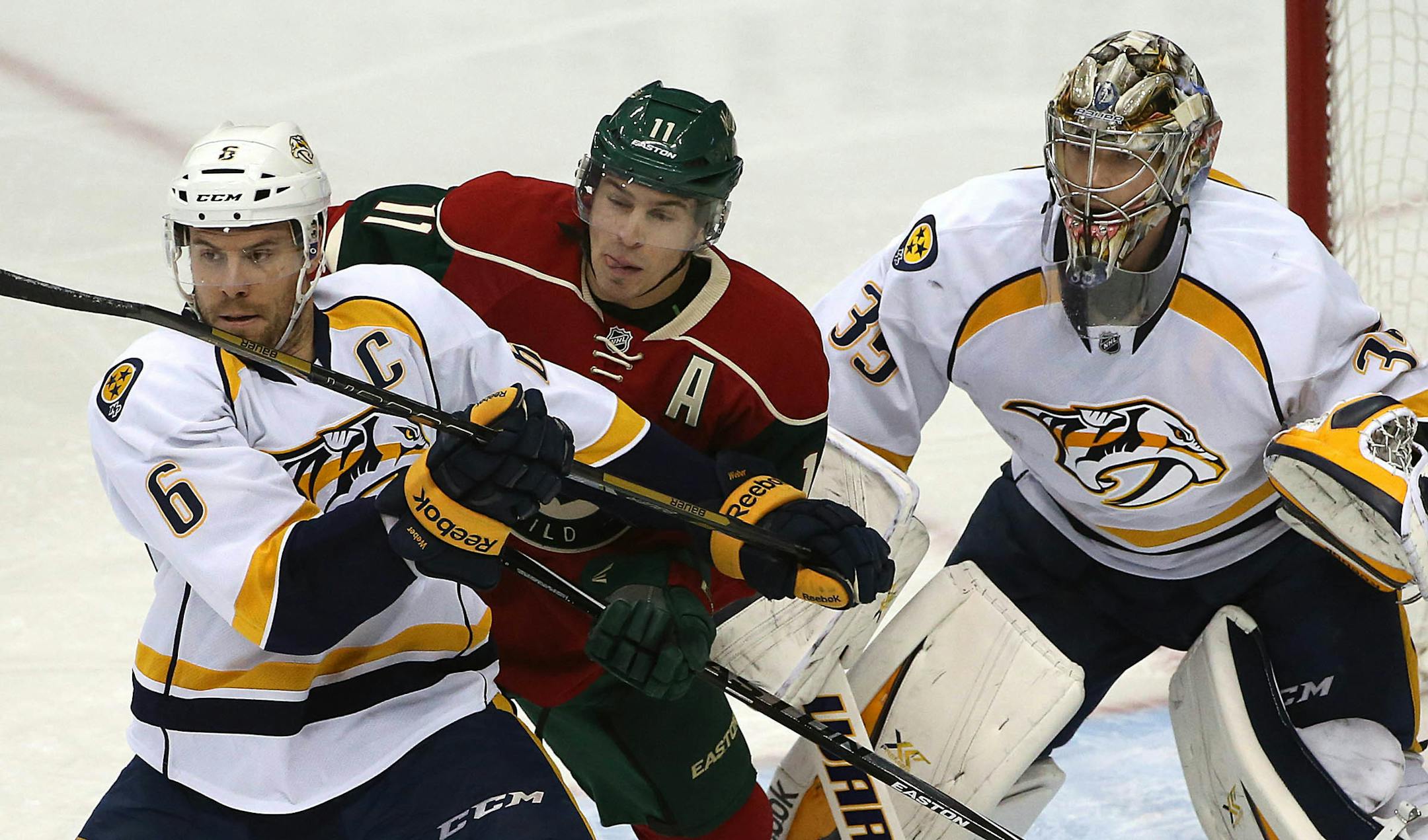 Minnesota Wild forward Zach Parise (middle) battled in front of the Nashville net with Nashville's Shea Weber (left). Nashville goalie is Pekka Rinne.