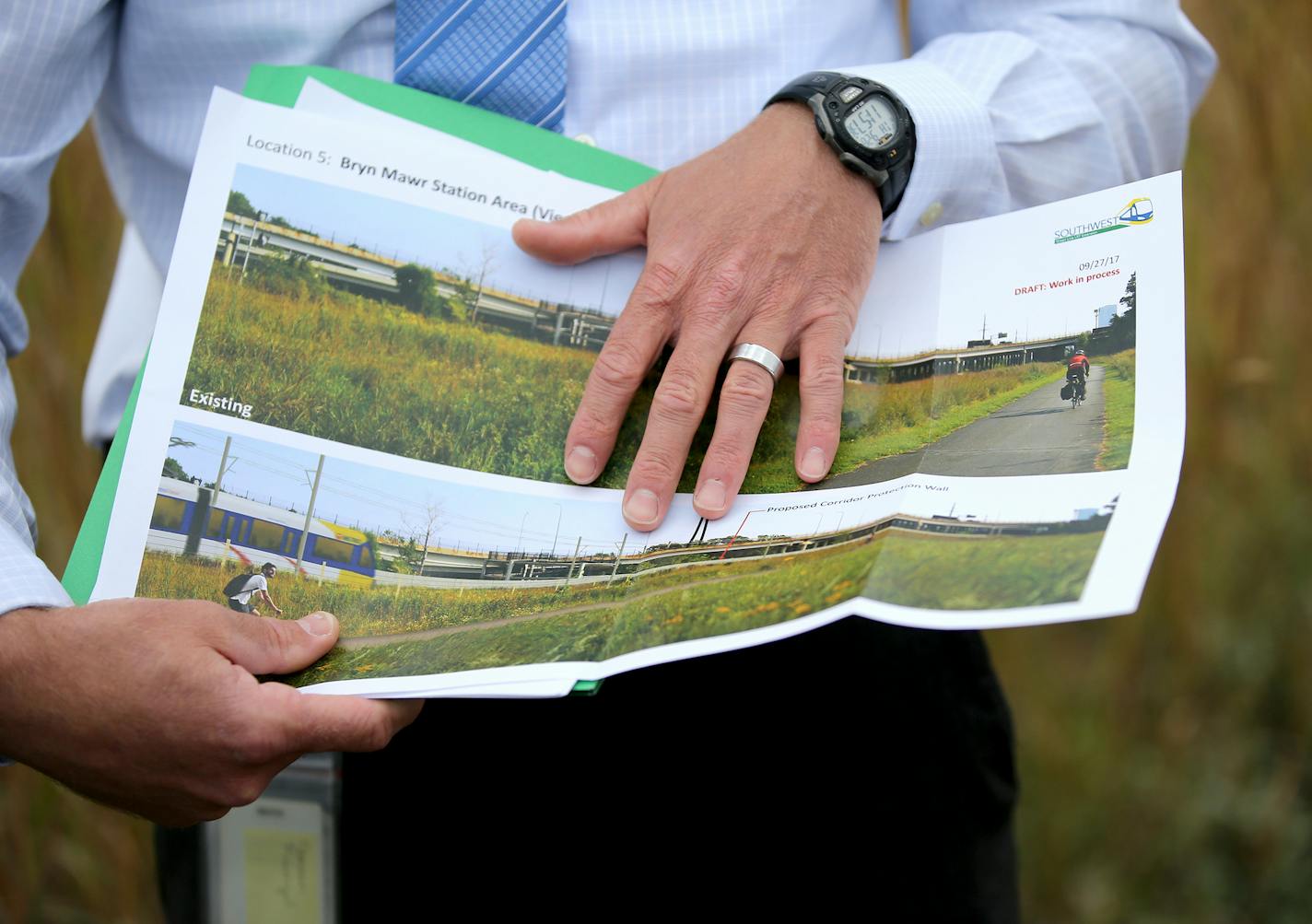 Southwest LRT officials will lead a tour of the area where a 10-foot wall is proposed. Here, Brian Runzel, SWLRT Construction Director, shows an artist's rendering of the Bryn Mawr Station Area during a tour Thursday, Sept. 28, 2017, in Minneapolis, MN.] DAVID JOLES &#xef; david.joles@startribune.com Controversy continues to stir over a proposed 10-foot concrete wall that will separate freight and light trains along the Southwest LRT route in Minneapolis. In an effort to appease its critics, the