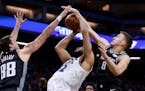 Timberwolves center Karl-Anthony Towns went to the basket between the Kings' Nemanja Bjelica, left, and Bogdan Bogdanovic during the first quarter Mon