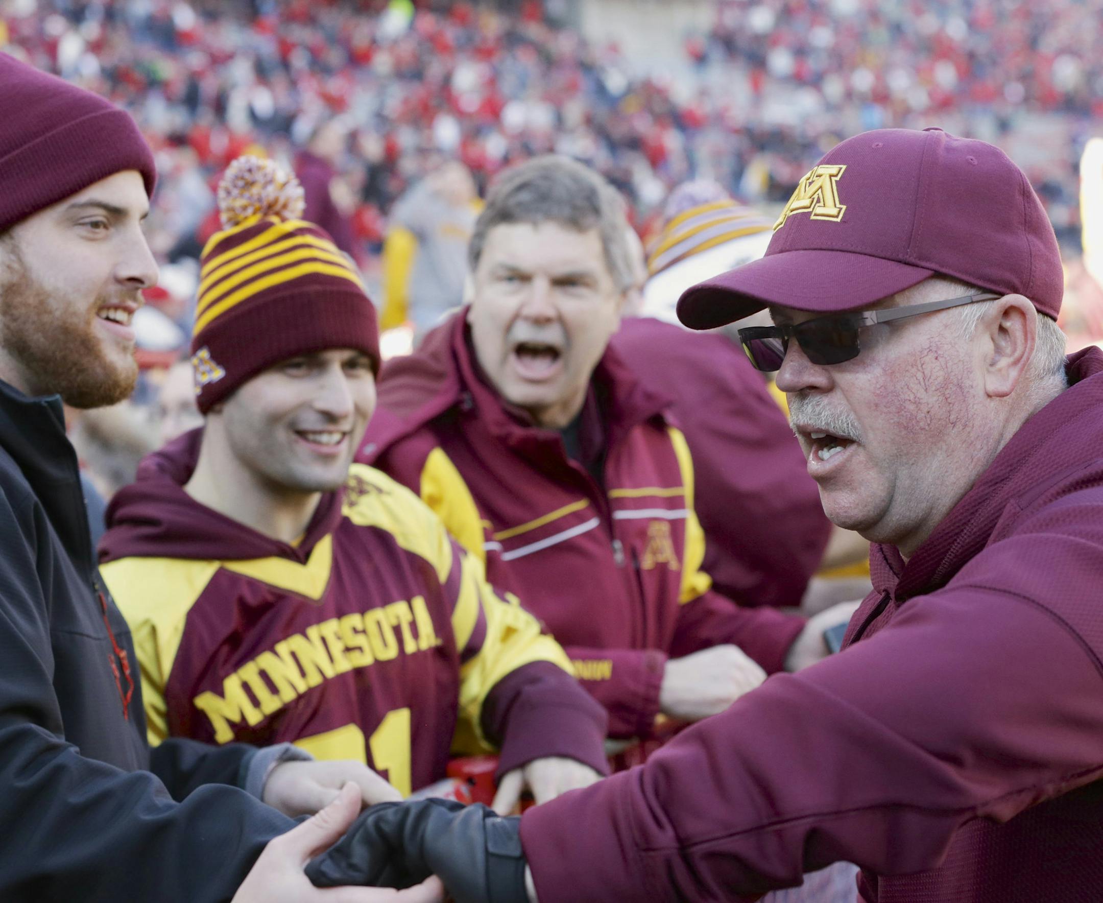 Minnesota head coach Jerry Kill, right, celebrates with fans a 28-24 win over Nebraska in an NCAA college football game in Lincoln, Neb., Saturday, Nov. 22, 2014.
