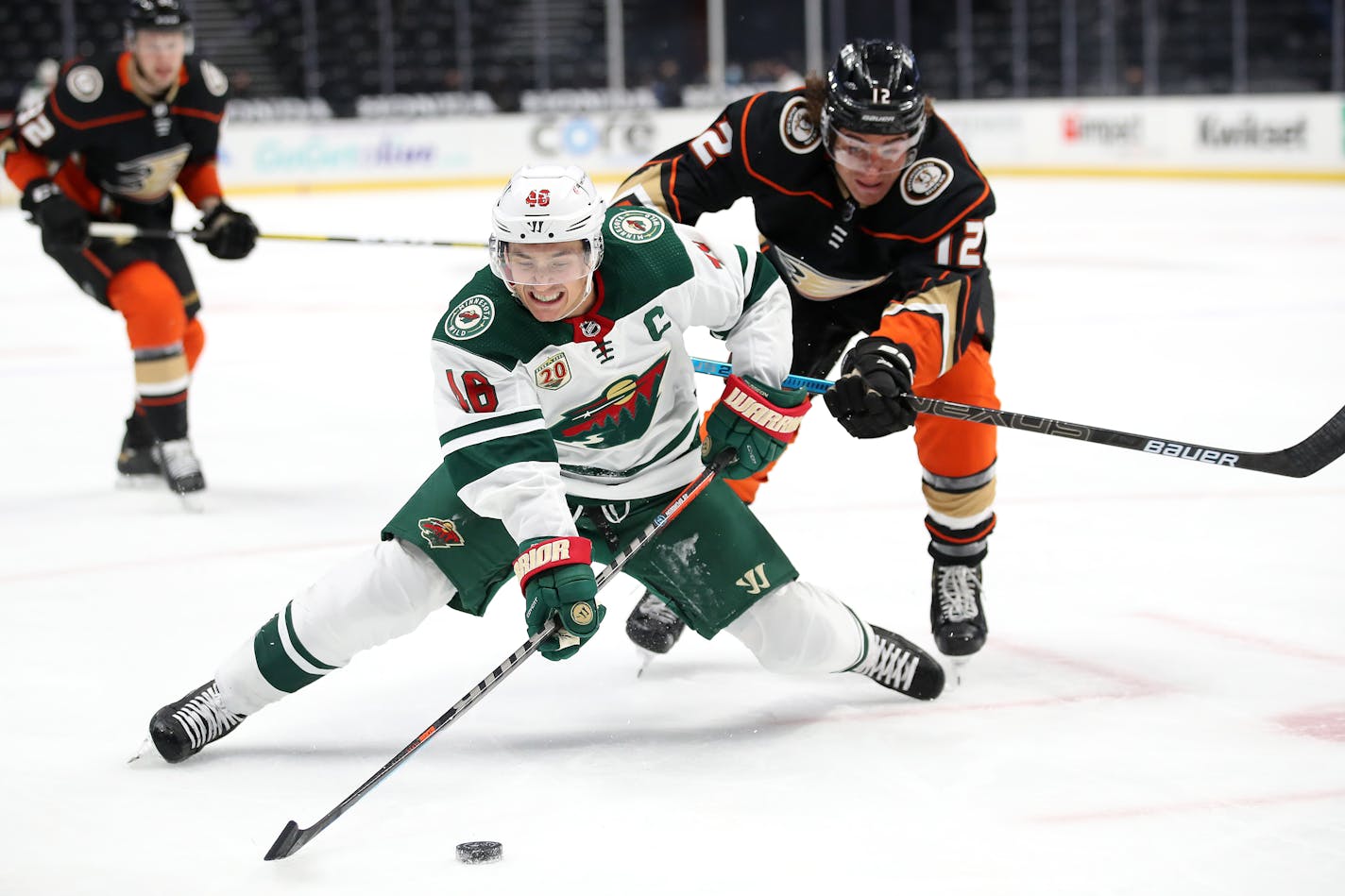 Sonny Milano #12 of the Anaheim Ducks pushes Jared Spurgeon #46 of the Minnesota Wild to the ice while chasing a puck during the third period of a game at Honda Center on Jan. 18, 2021 in Anaheim, California. (Sean M. Haffey/Getty Images/TNS) ORG XMIT: 6383395W