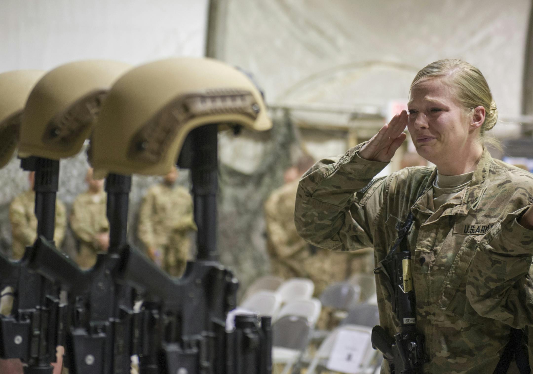 A U.S. service member salutes her fallen comrades during a memorial ceremony for six Airmen killed in a suicide attack, at Bagram Air Field, Afghanistan on Wednesday, Dec. 23, 2015. The deadliest attack in Afghanistan since 2013 killed six U.S. troops on Monday, including a family man from Long Island, New York; a South Texan; a New York City police detective; a Georgia high school and college athlete; an expectant father from Philadelphia; and a major from suburban Minneapolis with ties to the
