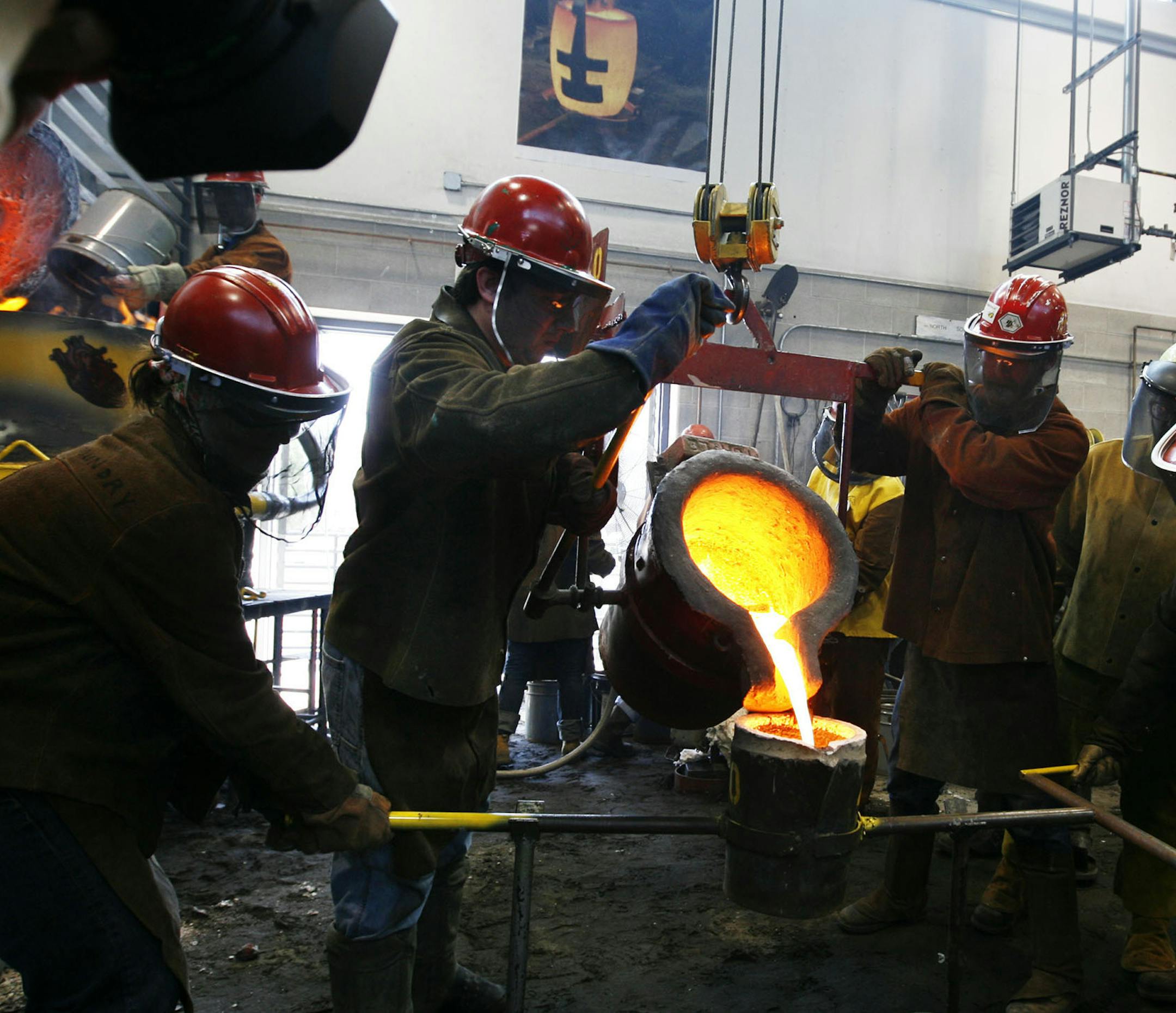DAVID JOLES ‚Ä¢ djoles@startribune.com Minneapolis, MN - April 17, 2009-] Molten metal is poured from a large ladle into a smaller one before being poured into molds during the 40th Annual Minnesota Iron Pour at the University of Minnesota in the Foundry Courtyard. Twenty five metal artists from around the U.S. as well as 32 University of Minnesota students participated in the event. Recycled radiators and other scrap metals were melted down in a cupola furnace with temps reachi