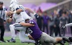 St. Thomas defensive lineman Brent Robley (49) got his arm around Butler quarterback Bret Bushka (4) as he scrambled out of the pocket in the second q