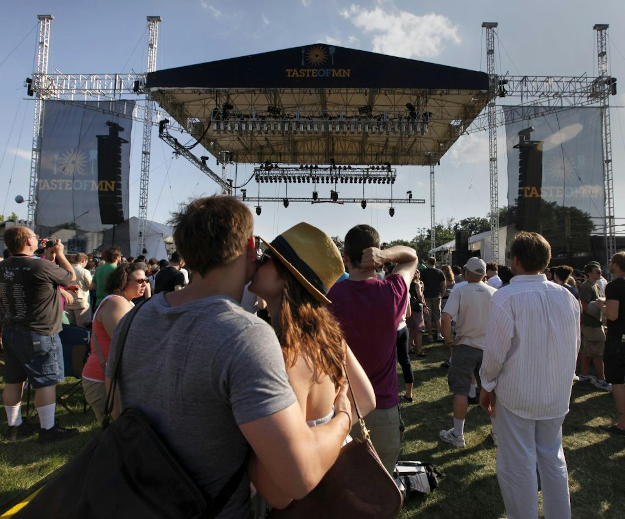 Amy Stafford plants a kiss on Travis Munson's check during the 'Walkman' st at the opening day at the The Taste of Minnesota.