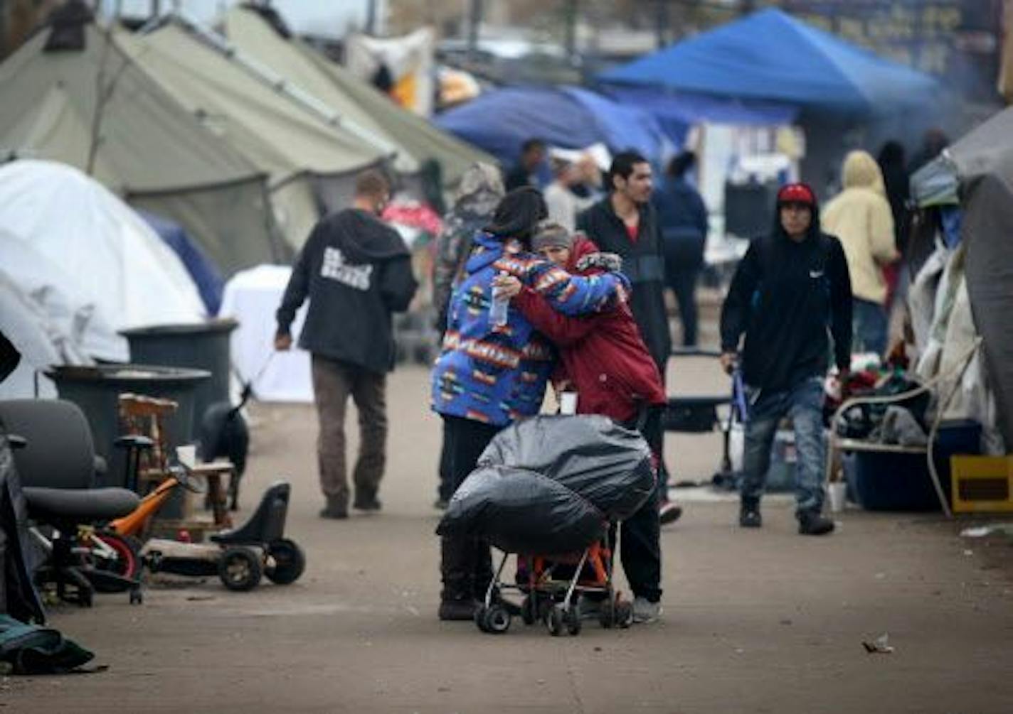 More than 50 people have moved out of the large homeless encampment along Hiawatha Avenue in the past few months, the result of a massive outreach effort by city, county and American Indian agencies. Ellen Eagletail, left, hugs and comforts a resident of the encampment who had earlier witnessed a man physically assaulted.