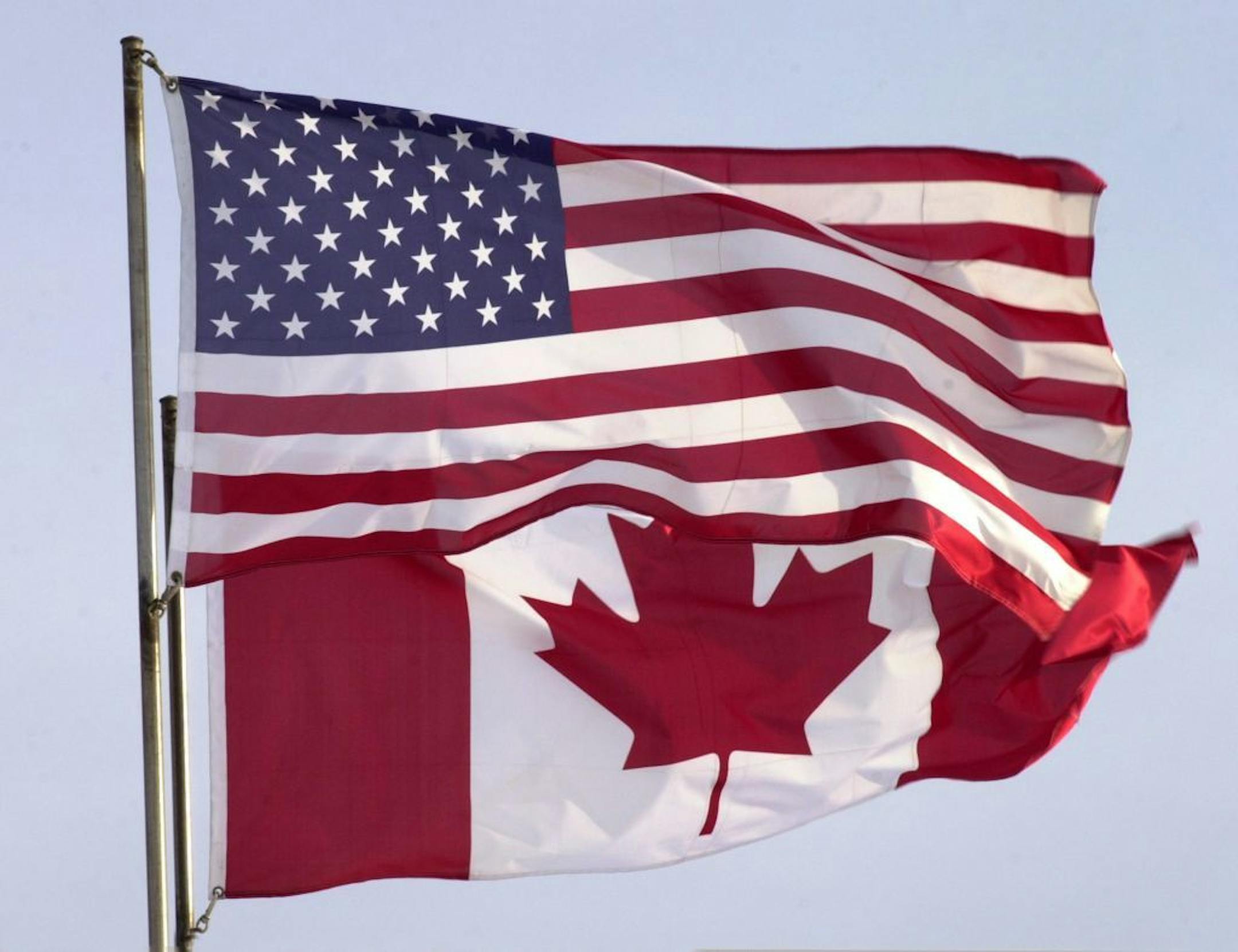 Canadian and American flags fly side-by-side near the airport in Thunder Bay, Ontario.