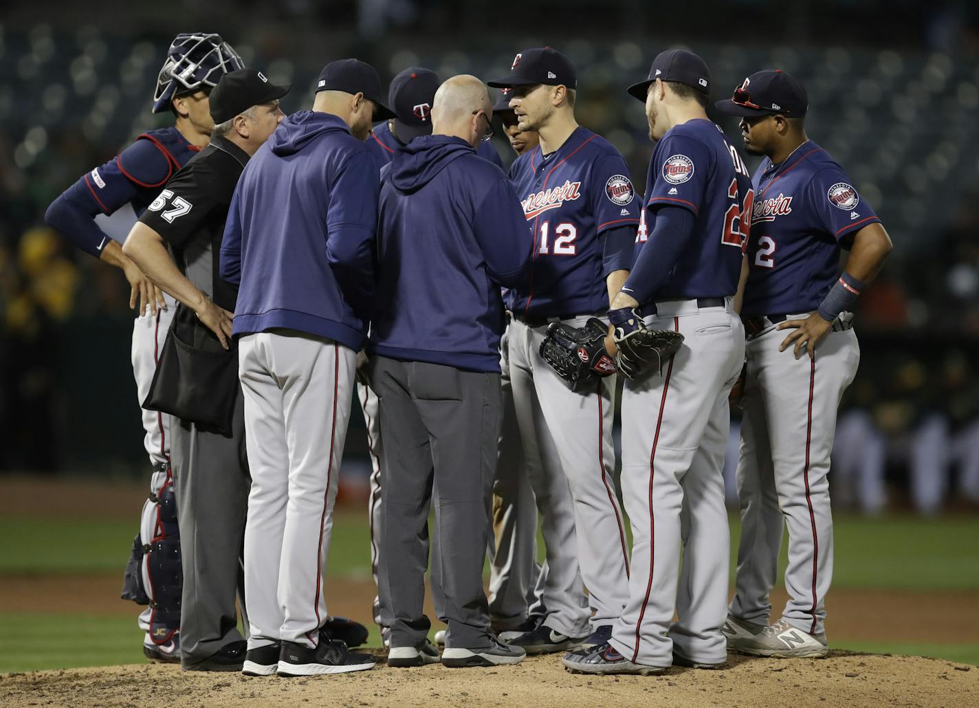 Minnesota Twins pitcher Jake Odorizzi (12) meets with a trainer on the mound in the fourth inning of a baseball game against the Oakland Athletics Tuesday, July 2, 2019, in Oakland, Calif. (AP Photo/Ben Margot)