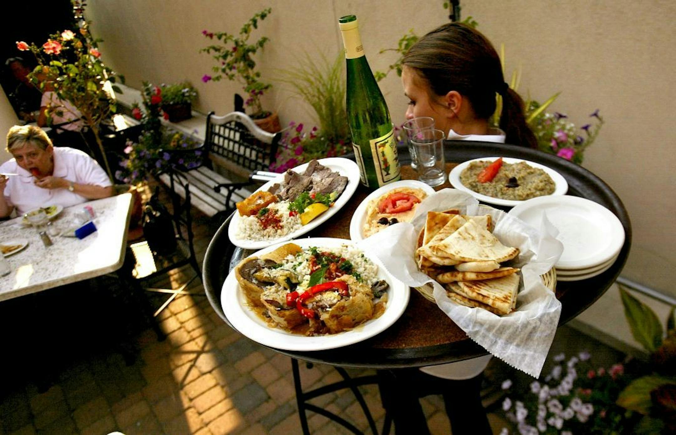 It's Greek To Me, serves up authentic Greek food and has a large outdoor seating area attached to the restaurant. Ena Englund hoists a tray of hearty, moderately-priced fare.....The Minneapolis, MN neighborhood, Lynlake, has been an established area for years, However over the past several years Places like the Three Muses, JP's, LaBodega and others have joined the main stays such as "It's Greek to Me" in providing a interesting melting pot of restaurants and shops for folks to spend time enjoyi