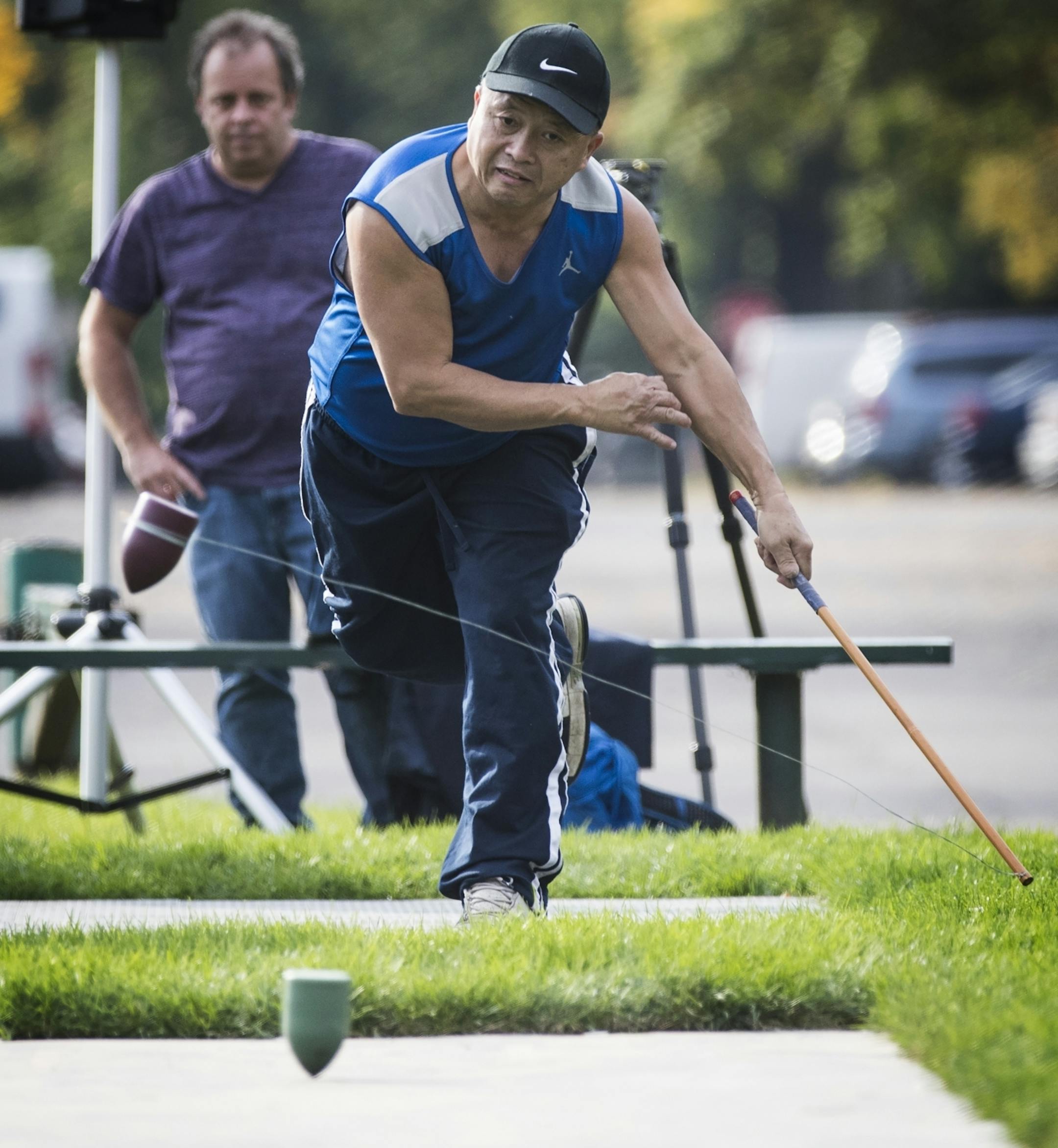 Young Vang demonstrates the game of Tuj Lub.