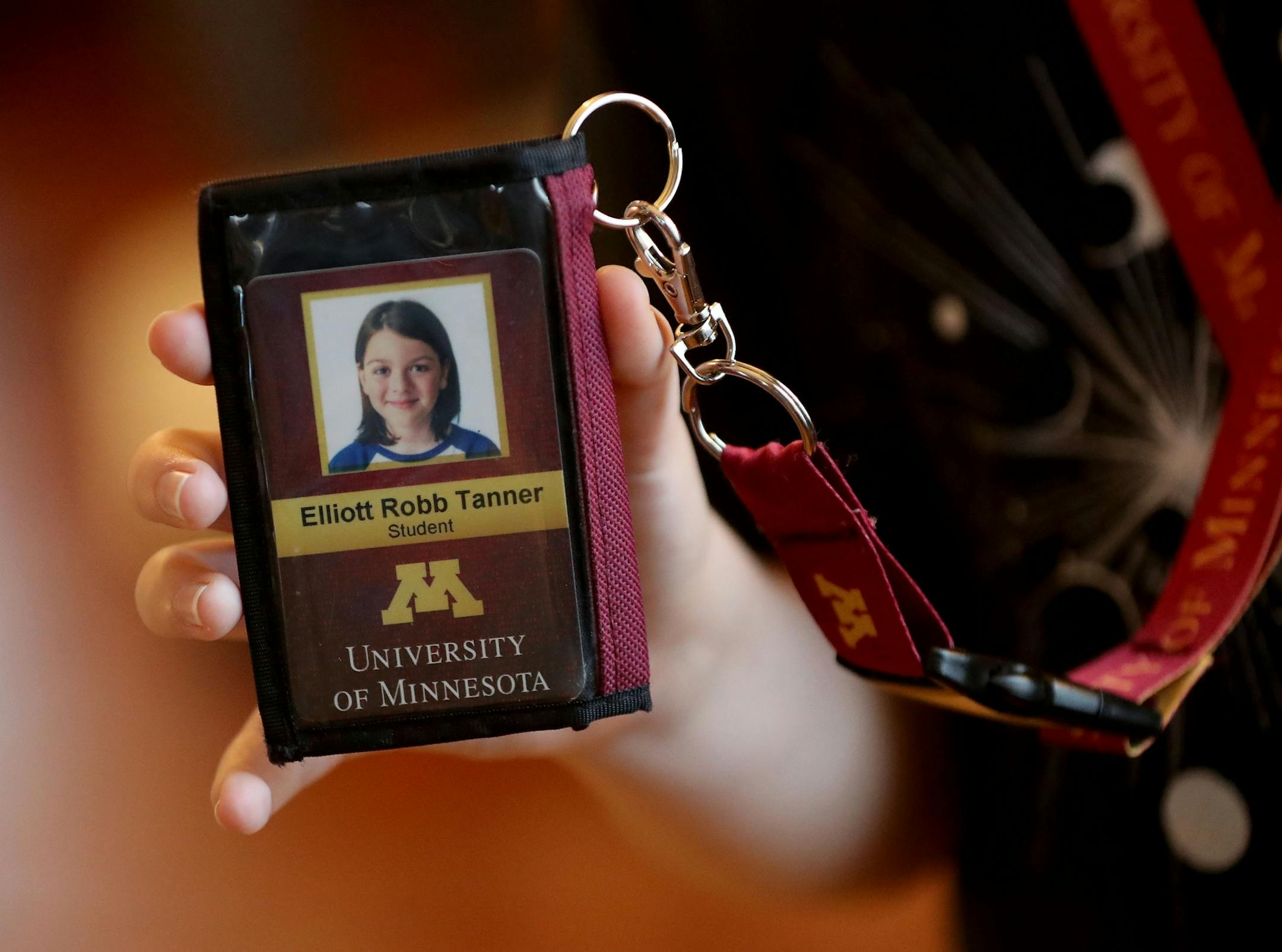 Elliott Tanner, 11, a junior at the University of Minnesota, holds his university identification.