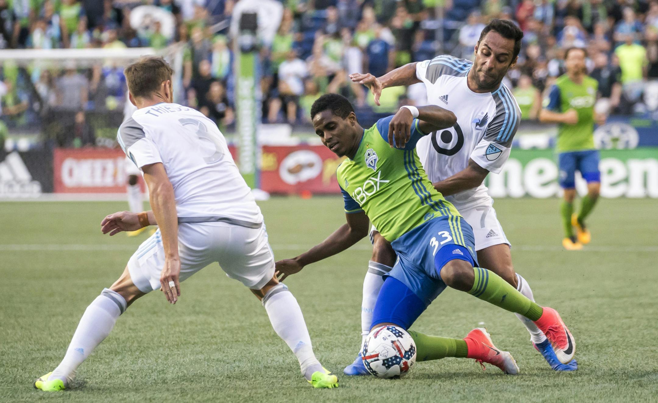 Seattle Sounders defender Joevin Jones is pressured by Minnesota United midfielders Ibson, right, and Jerome Thiesson, left, during an MLS soccer match Sunday, Aug. 20, 2017, in Seattle. (Bettina Hansen/The Seattle Times via AP)