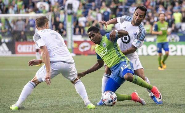 Seattle Sounders defender Joevin Jones is pressured by Minnesota United midfielders Ibson, right, and Jerome Thiesson, left, during an MLS soccer matc