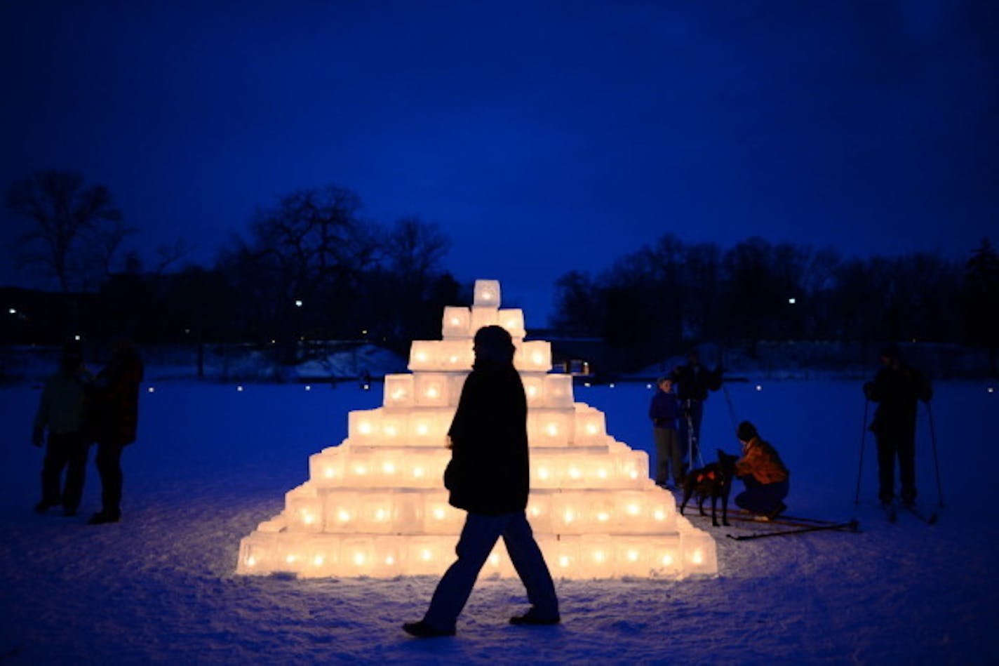 Brian Hackbarth, of Lake of the Isles, walked past an illuminated ice pyramid on Lake of the Isles during the Luminary Loppet Saturday night.   ] (AARON LAVINSKY/STAR TRIBUNE) aaron.lavinsky@startribune.com  The Luminary Loppet night of the City of Lakes Loppet Ski Festival was held Saturday, Feb. 6, 2016 at Lake of the Isles in Minneapolis, Minn.