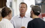 Ohio Gov. John Kasich talks with Joshua Bowman, right, and Joe Shean during a visit at RP Abrasives, Monday, July 13, 2015, in Rochester, N.H.