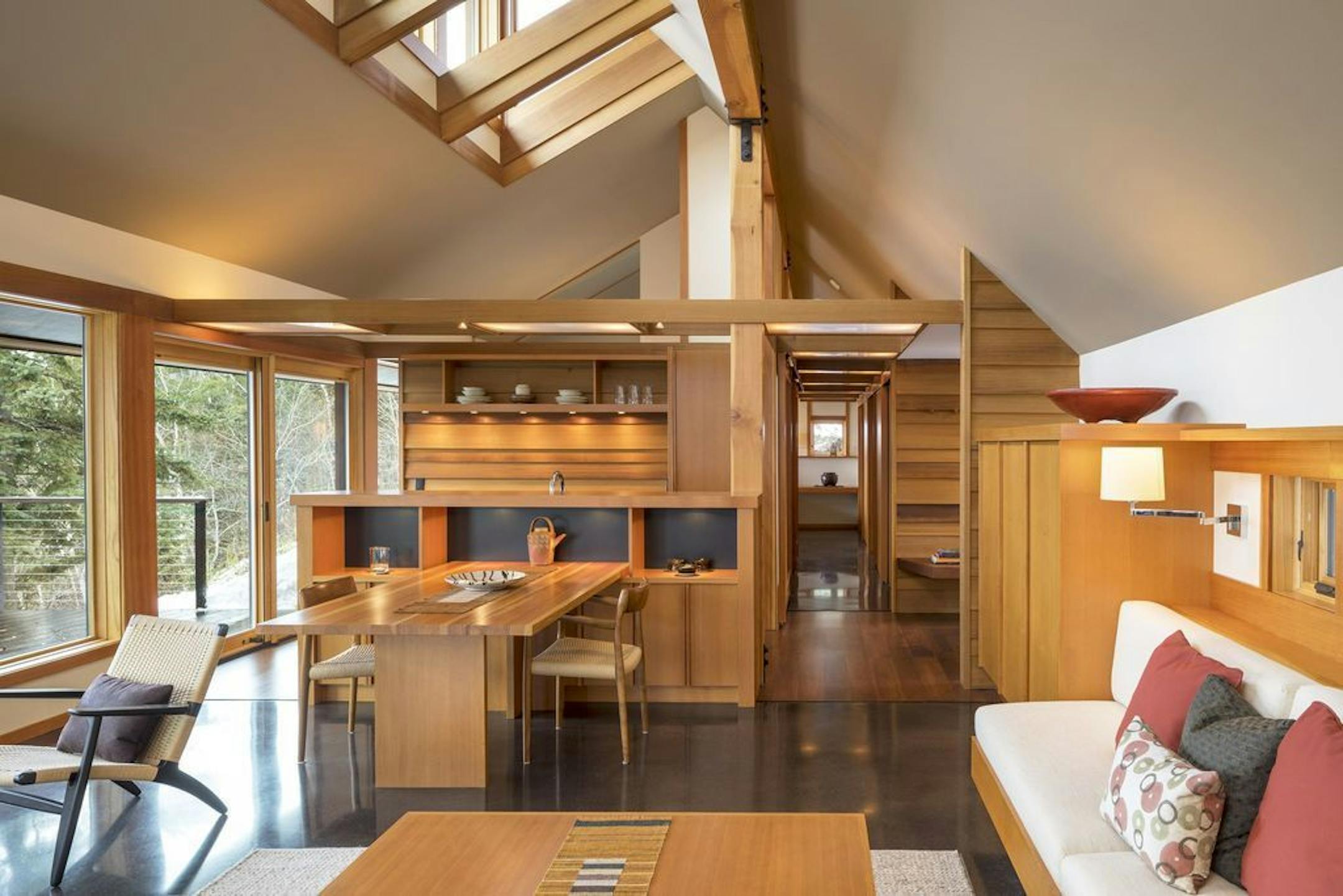 The cabin's light-filled living spaces composed of expanses of glass, Douglas fir built-ins and heated concrete floor.
