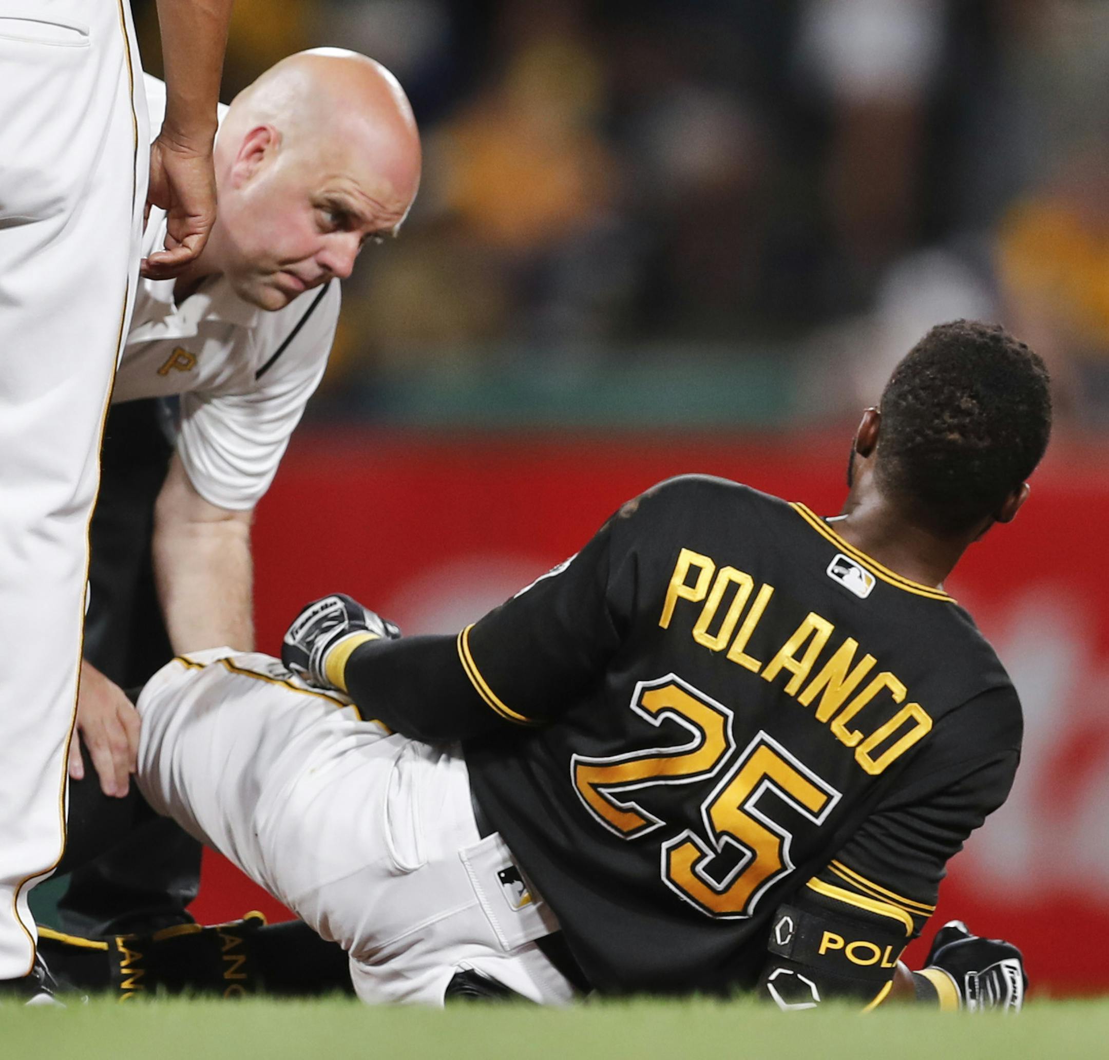 Pittsburgh Pirates trainer Bryan Housand, left, looks over Gregory Polanco's injured leg in the sixth inning of a baseball game against the Miami Marlins, Friday, Sept. 7, 2018, in Pittsburgh. (AP Photo/Keith Srakocic) ORG XMIT: PAKS115