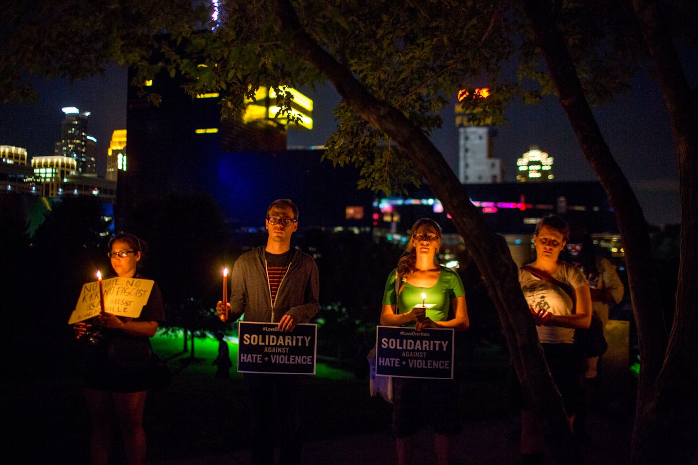 People stand atop a hill for a candlelight vigil in solidarity with Charlottesville, Va., counterprotesters at Gold Medal Park, on Saturday night in Minneapolis.