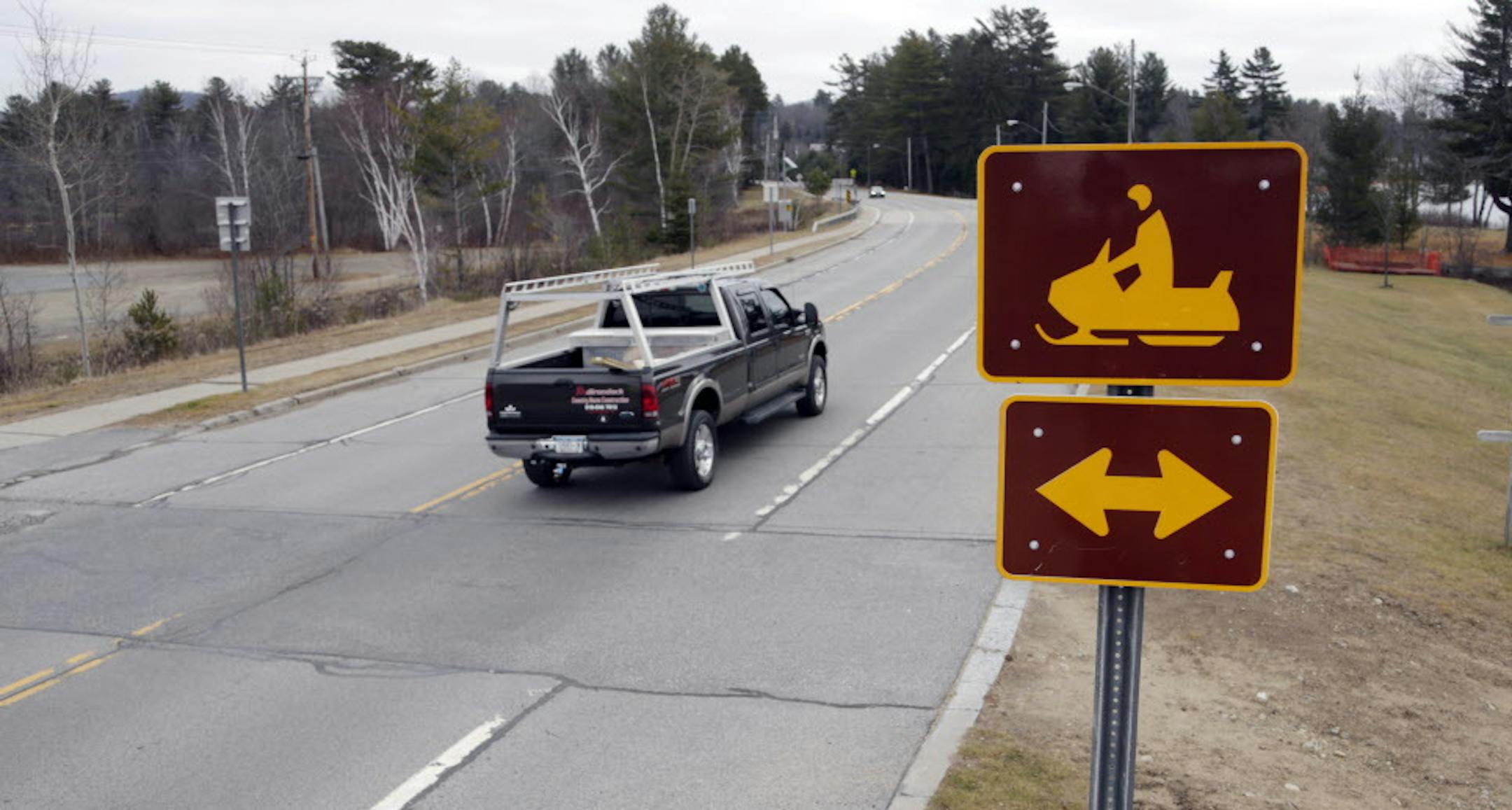 A snowmobile crossing sign is seen along Route 30 on Tuesday, Dec. 8, 2015, in Speculator, N.Y. Some Northeasterners are beginning to wonder if a white Christmas may just be a dream, and business owners who rely on snow are starting to worry if warm weather could lead to a nightmare winter. (AP Photo/Mike Groll)