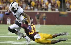 TCU wide receiver Josh Doctson is tackled by Minnesota Gophers defensive back Eric Murray as he carried the ball in the second quarter.