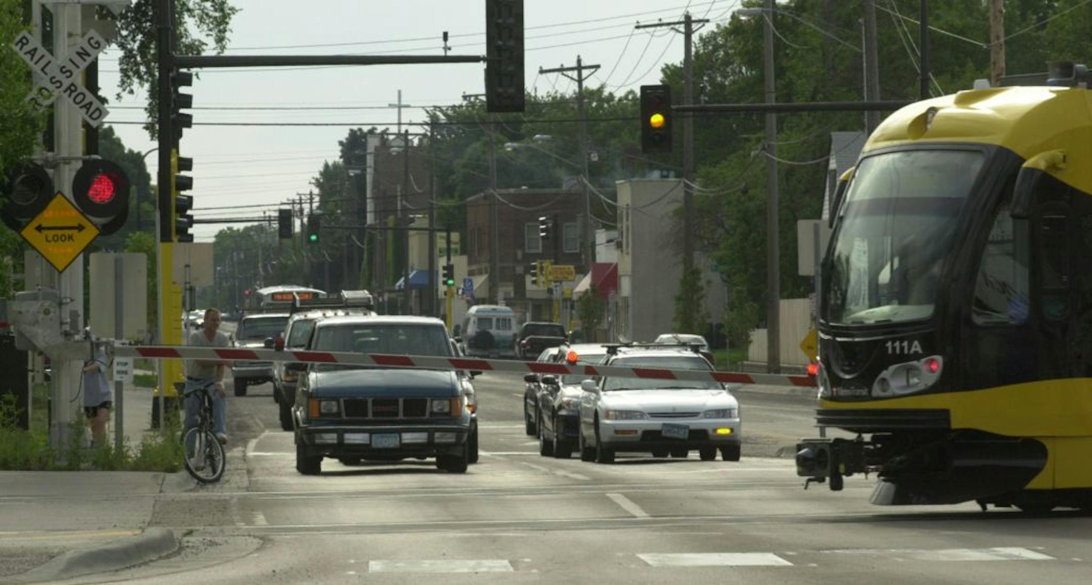 Heather Charles/ Staff Photographer Minneapolis, MN: 7/22/04: Cars stop behind the light rail crossing arms on East 38th Street and Hiawatha Avenue as the light rail passes in front early Thursday evening in Minneapolis. GENERAL INFORMATION: The light rail crossings.