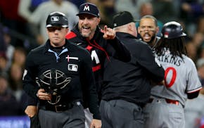 Twins manager Rocco Baldelli, center, argues with home plate umpire Austin Jones, left, as shortstop Carlos Correa, second from right, is held back by