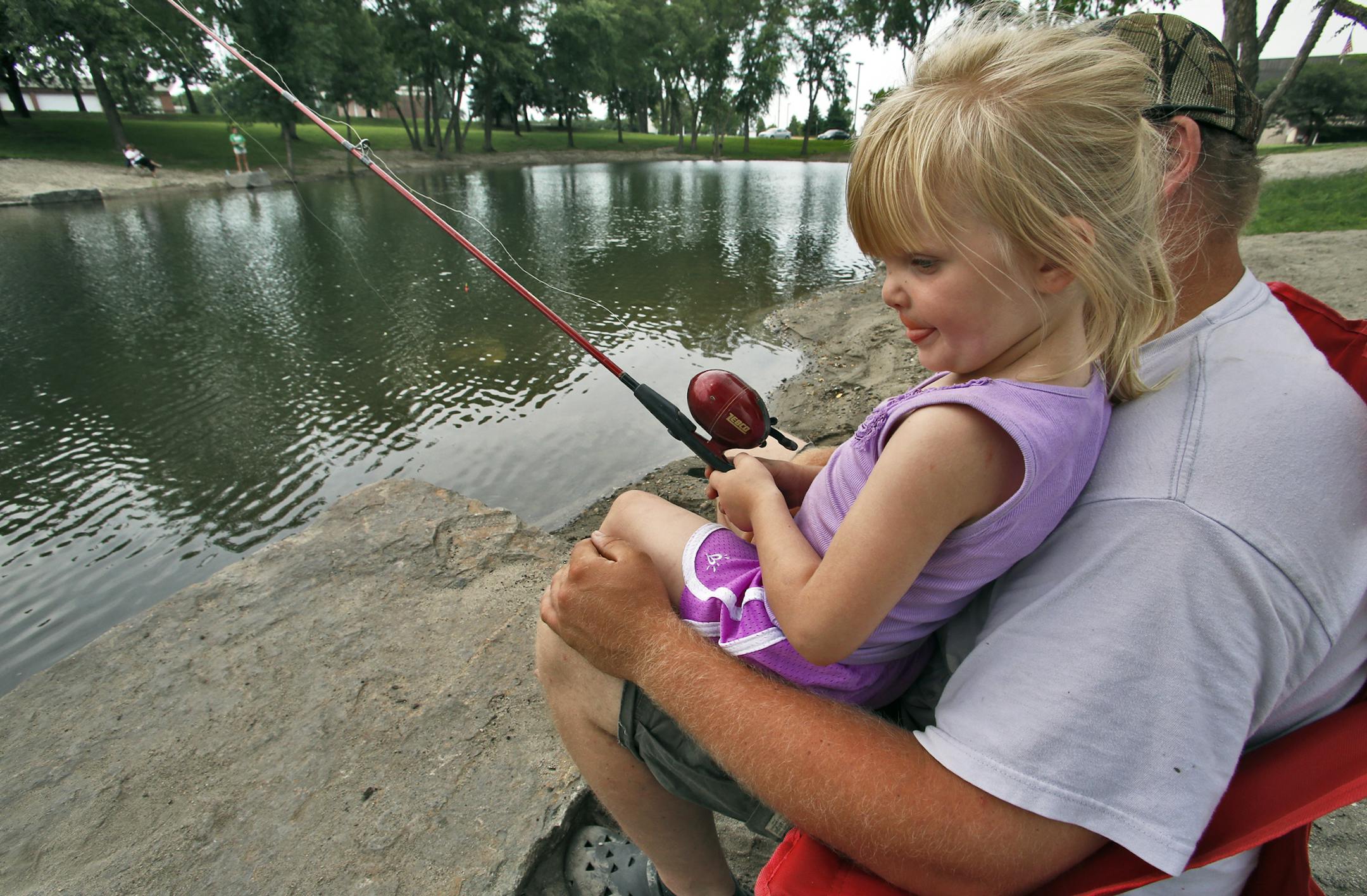 The DNR recently stocked a pond in front of the Brooklyn Park Community Center with more than 1,000 bluegills and yellow perch. Madison Lenhart, 4, with the help of her uncle Mike Boettner, both of Brooklyn Park, attempted to lure a few of the fish to their hook. (MARLIN LEVISON/STARTRIBUNE(mlevison@startribune.com The DNR recently stocked a pond in front of the Brooklyn Park Community Center with more than 1,000 bluegills and yellow perch. Madison Lenhart, 4, with the help of her uncle Mike Boe