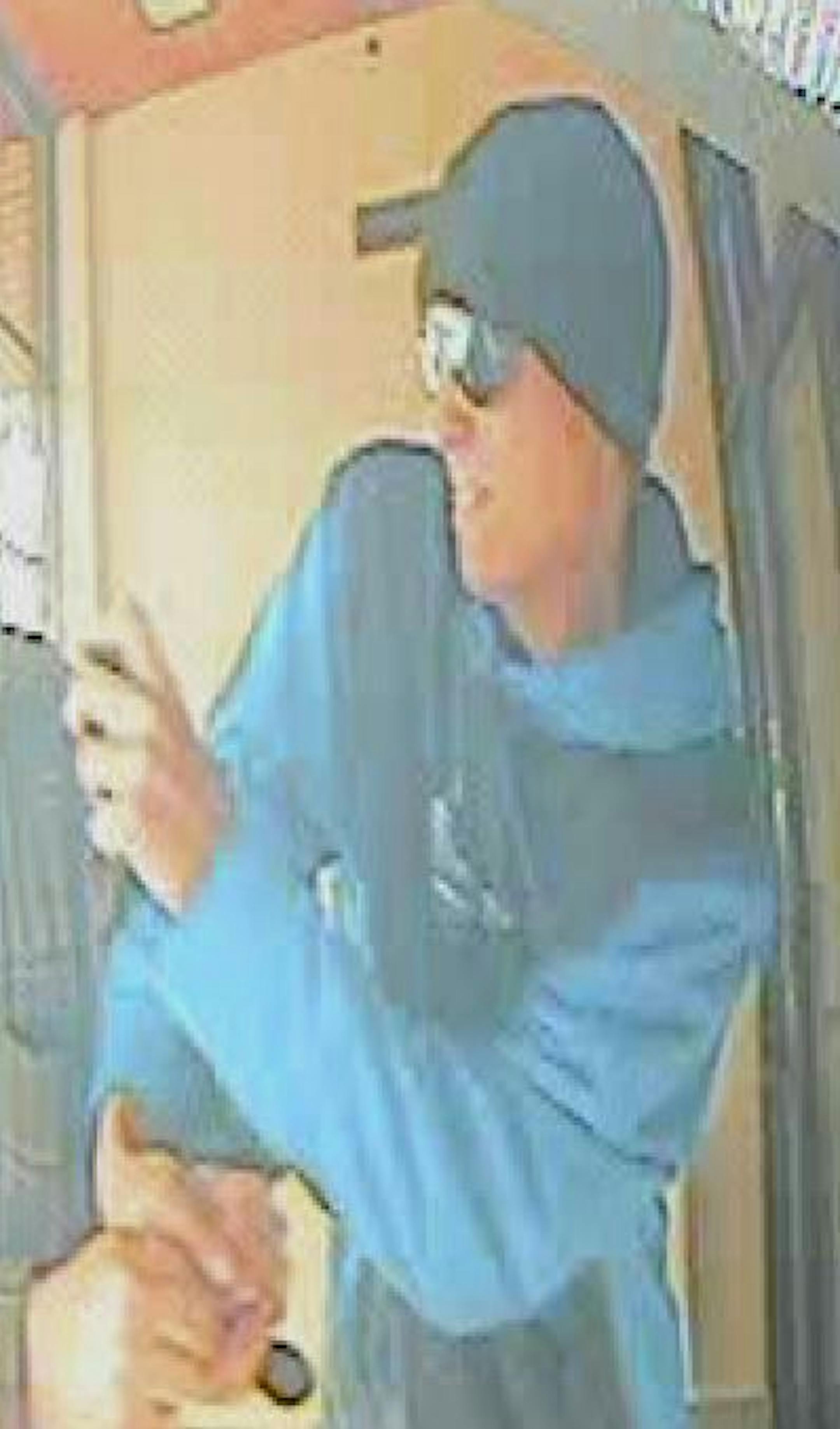 A security photo shows a suspect with spray in his hand and a finger on the pump as he confronted his victim during an ATM robbery in Andover.