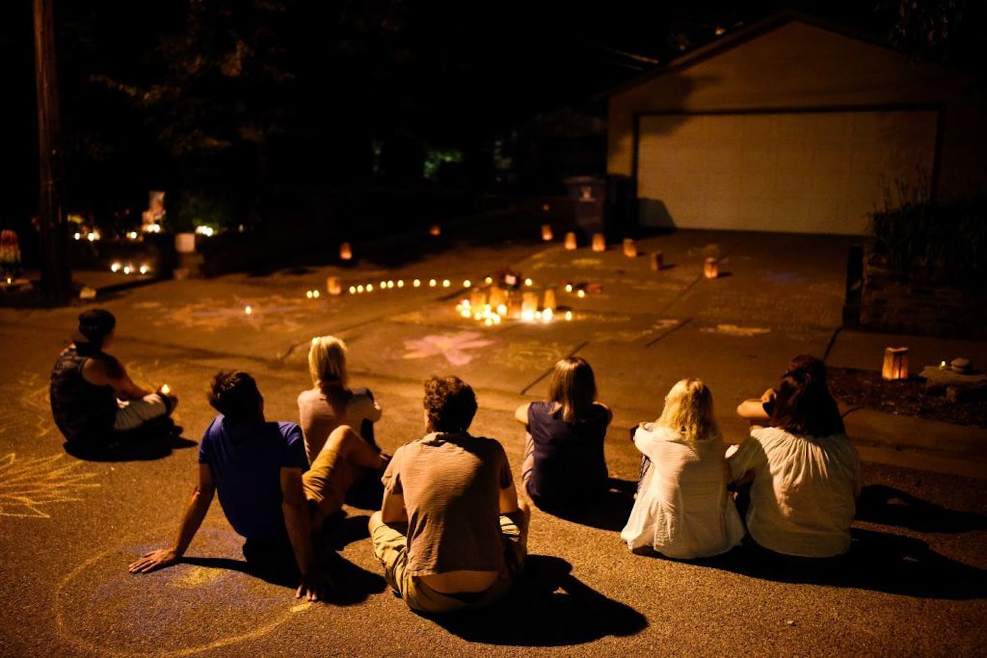 Friends and neighbors of Justine Damond Ruszczyk sat in silence near the spot where she was killed one year ago by Minneapolis Police officer Mohamed Noor .