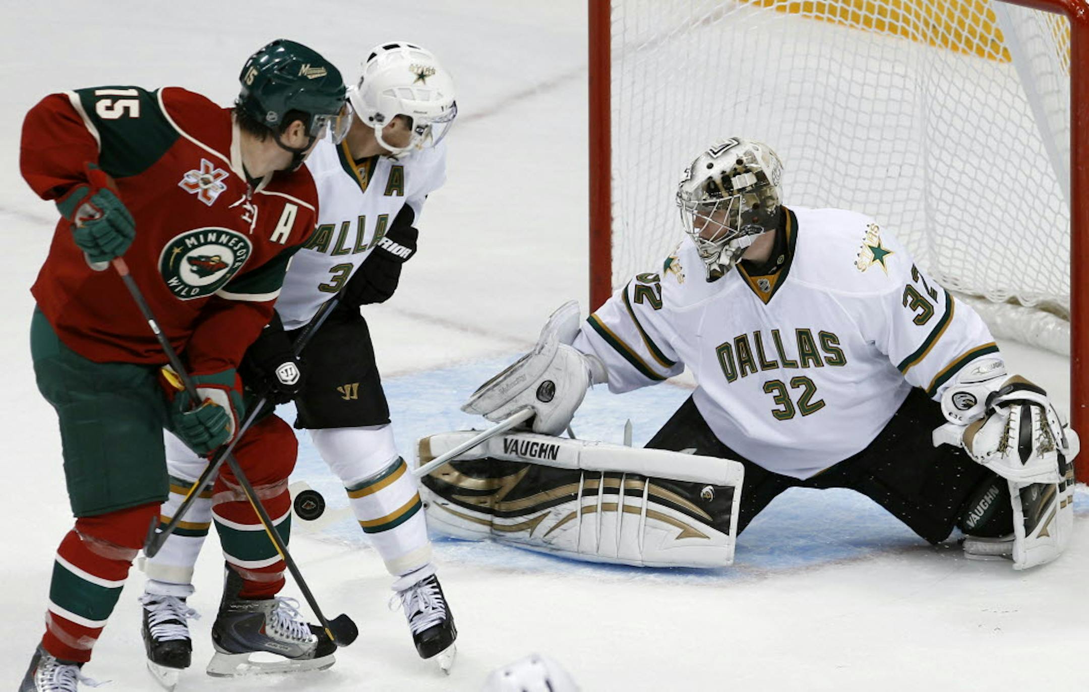 The Wild's Andrew Brunette, left, and Dallas' Stephane Robidas (3) watched as Stars goalie Kari Lehtonen deflected a shot.