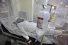 FILE - In this Thursday, Oct. 19, 2017 file photo, a patient suffering from dengue fever lies in a hospital bed in Peshawar, Pakistan. Cases of dengue